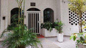 A courtyard with potted plants, a gated entrance, and a building with a tiled floor. - 6 Minutes From Copacabana Beach Rdl1112 (Rio de Janeiro)