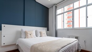 A bedroom with a large bed, a white headboard, and a window with a view of buildings. - 6 Minutes From Copacabana Beach Rdl1112 (Rio de Janeiro)
