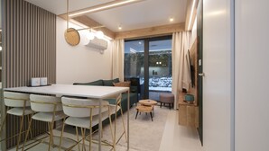Een moderne keuken met een wit aanrecht, goudkleurige stoelen en een houten eettafel.
