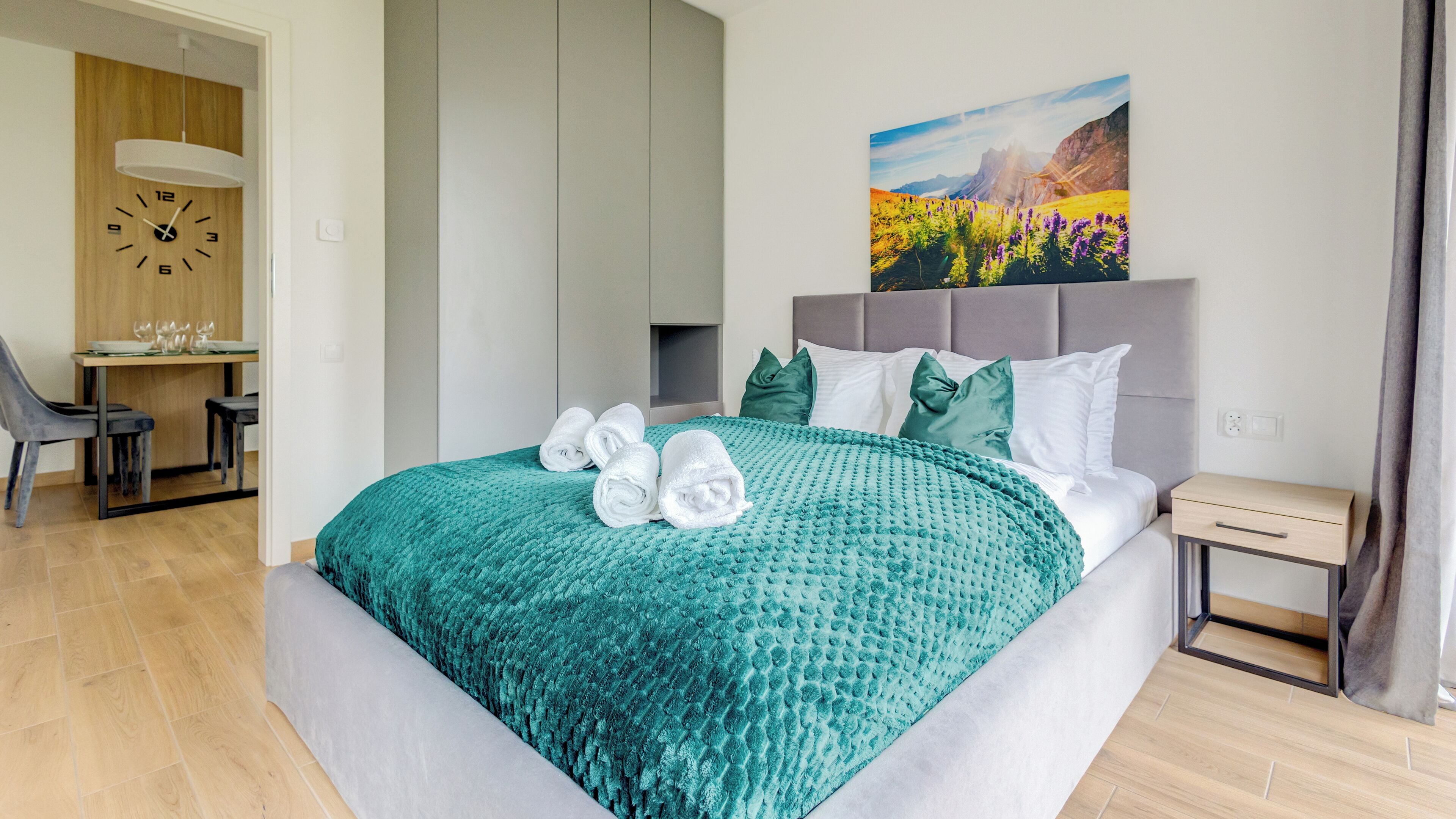 Une chambre d’hôtel moderne, équipée d’un lit, d’un bureau et ornée d’un tableau au mur.
