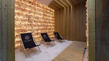 Relax in a stylish space with a unique stone wall, lounge chairs, and warm ambiance.