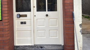 Una porta doble amb una placa que indica el número 19 i una closca de correu.