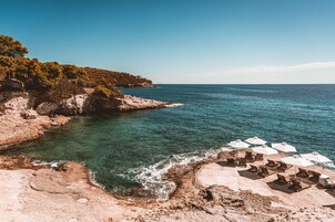 On the beach, black sand, sun loungers, beach umbrellas