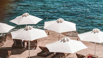 On the beach, black sand, sun-loungers, beach umbrellas