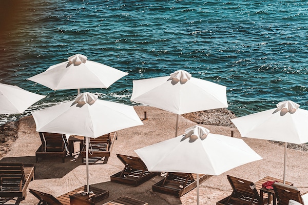 On the beach, black sand, sun loungers, beach umbrellas