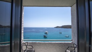 Un balcón con vista al mar, que incluye varios barcos y un cielo despejado.