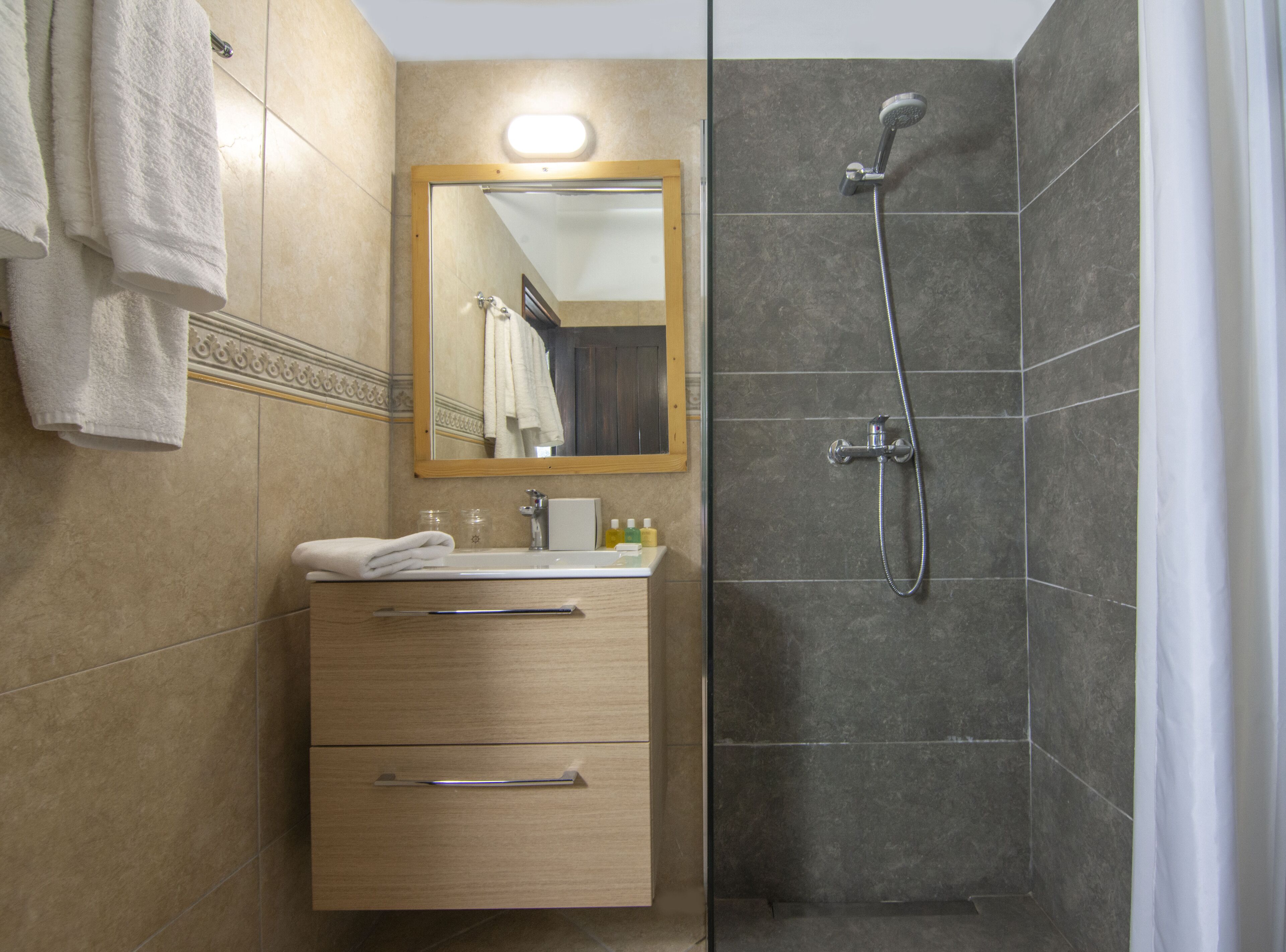 Une salle de bain avec un lavabo, un miroir et une douche.