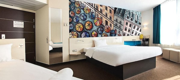 A hotel room with a large bed, a desk, a chair, and a wardrobe. - B&B Hotel Lublin Centrum (Lublin)