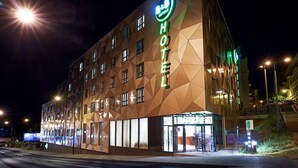 Un hotel con fachada geométrica y señalización iluminada.