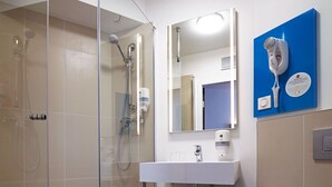 A modern bathroom with a glass-enclosed shower, a white sink, and a blue towel rack. - B&B Hotel Lublin Centrum (Lublin)