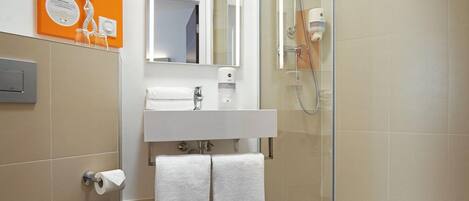 Un baño moderno con inodoro, lavamanos y ducha.