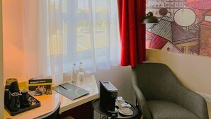 A hotel room with a desk, chair, and a small table with a lamp. - B&B Hotel Lublin Centrum (Lublin)