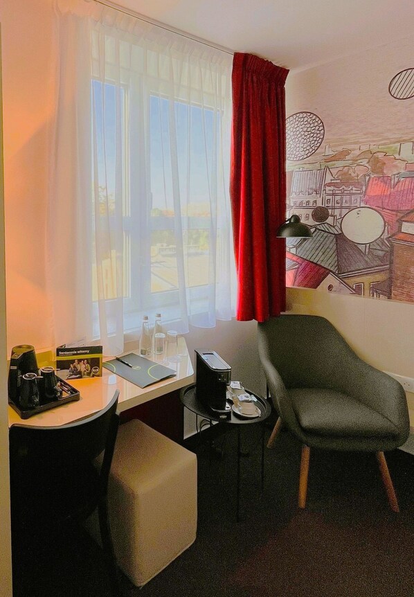 A hotel room with a desk, chair, and a small table with a lamp. - B&B Hotel Lublin Centrum (Lublin)