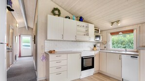 A modern kitchen with white cabinets, a built-in oven, a microwave, and a sink. - Stunning home in Hemmet with WiFi (Hemmet)