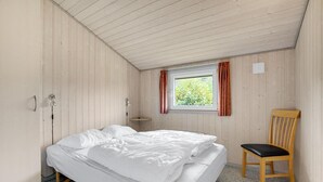A single bed with white bedding in a room with wooden walls and a sloped ceiling. - Stunning home in Hemmet with WiFi (Hemmet)