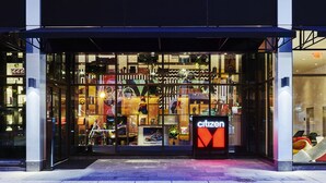 A modern building with a glass storefront displaying various items.
