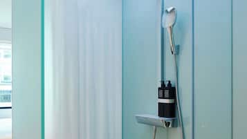 A modern shower with a glass enclosure, a handheld showerhead, and a wall-mounted faucet.