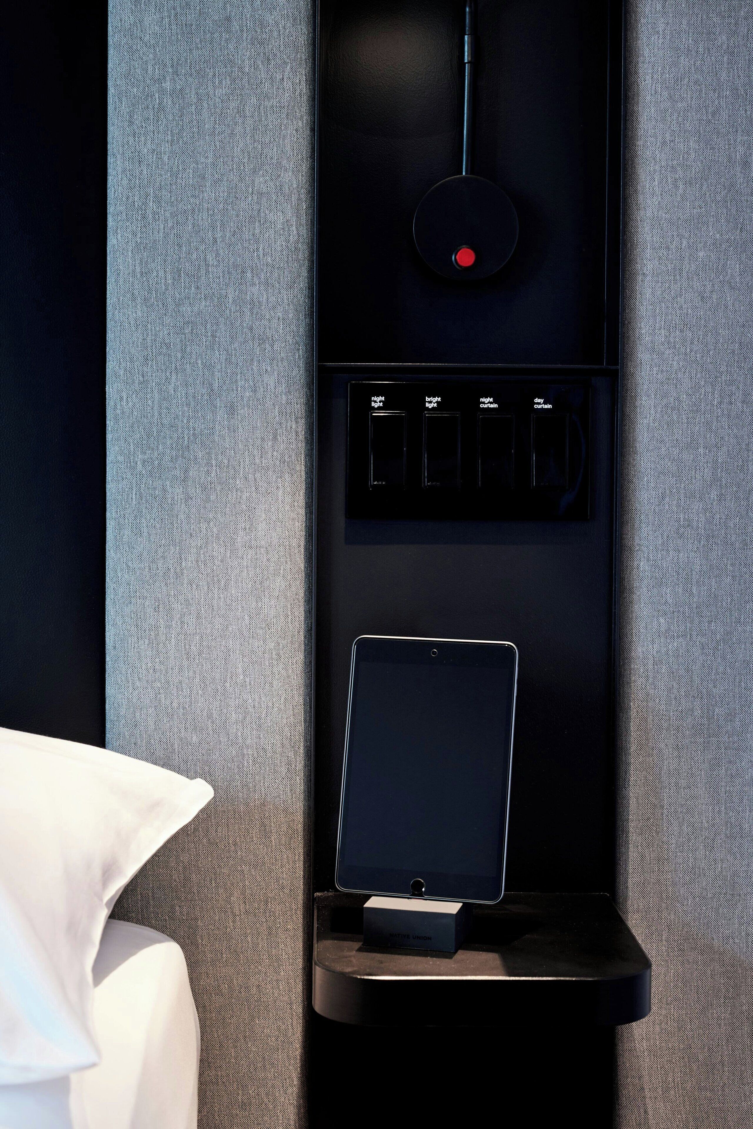 A black electronic device with a red button and a screen displaying options like 'bright light' and 'night curtain.'