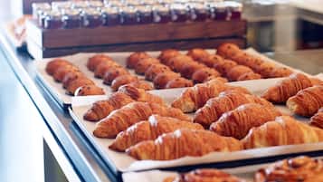 Una vitrina de pastelería con diversos pasteles y pan.