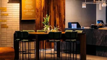 Un restaurante moderno con una pared de madera y una pizarra de menú. Hay varias mesas y sillas.