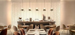 A modern dining area with a long table, chairs, and a bar counter.