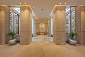 A hotel lobby with a central seating area, large columns, and potted plants. - Pestana Cr7 Marrakech (Marrakech)