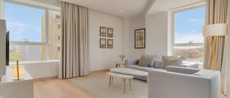 Una sala de estar moderna con un sofá, una mesa de centro y un televisor.