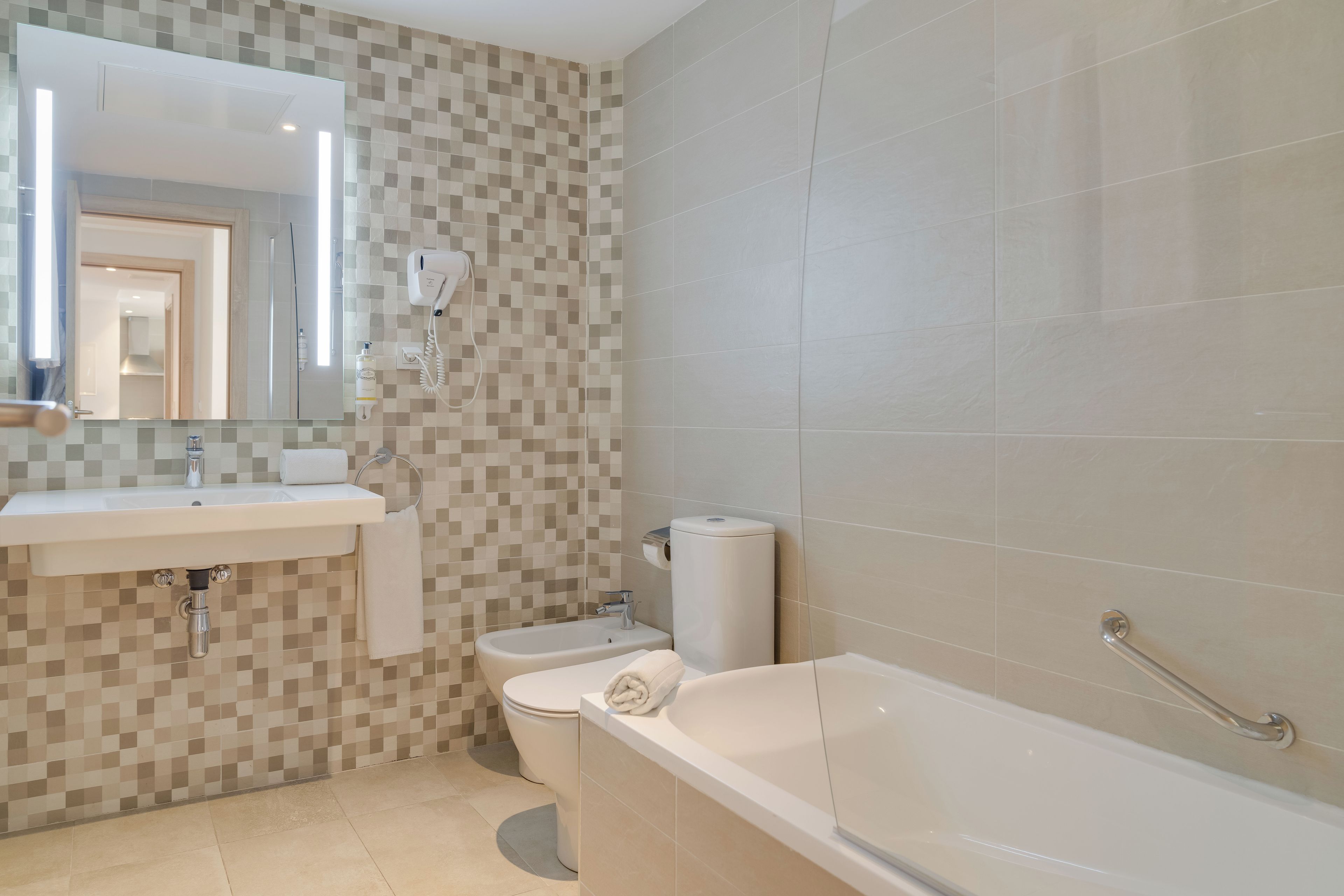 Un baño moderno con lavabo, inodoro y bañera.