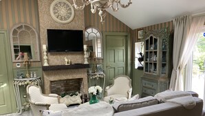 A living room with a fireplace, a television, and a green door.