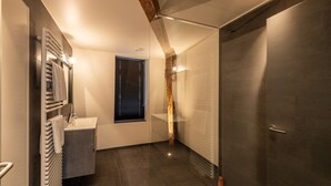 A modern bathroom with a glass shower enclosure, a built-in sink, and a towel rack. - Spacious Duplex Close to all Cultural Sites (Brussel)