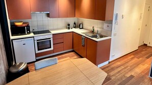 Eine moderne Küche mit Holzausstattung, einem Backofen, einer Mikrowelle und einem Spülbecken.