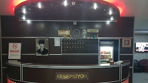 Un mostrador de recepción con una placa que dice "RESEPSİYON" y un cartel que prohíbe fumar.