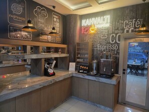 A restaurant interior with a counter, menu boards, and a coffee machine. - Lotus Otel (Konya)