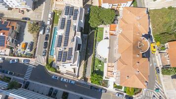 An aerial view of a cityscape with buildings, roads, and vehicles.