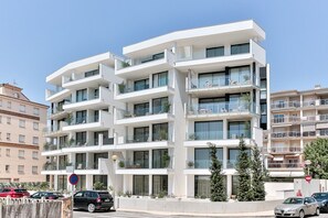 A modern multi-story residential building with balconies, a parking area, and a clear sky. - ECO-APARTMENTS LA MARINEDA & HOTEL THALASSA SPORT & SPA (Roses)