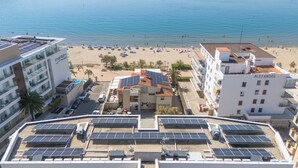 A hotel with multiple floors, a beach in the background, and solar panels on the roof. - ECO-APARTMENTS LA MARINEDA & HOTEL THALASSA SPORT & SPA (Roses)