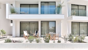 A modern two-story building with a pool, outdoor seating, and large windows. - ECO-APARTMENTS LA MARINEDA & HOTEL THALASSA SPORT & SPA (Roses)