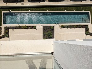 A rooftop pool with clear water, surrounded by concrete walls and small planters with greenery. - ECO-APARTMENTS LA MARINEDA & HOTEL THALASSA SPORT & SPA (Roses)