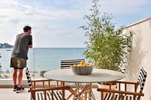 A balcony with a table, chairs, a bowl of fruit, and a potted plant. - ECO-APARTMENTS LA MARINEDA & HOTEL THALASSA SPORT & SPA (Roses)