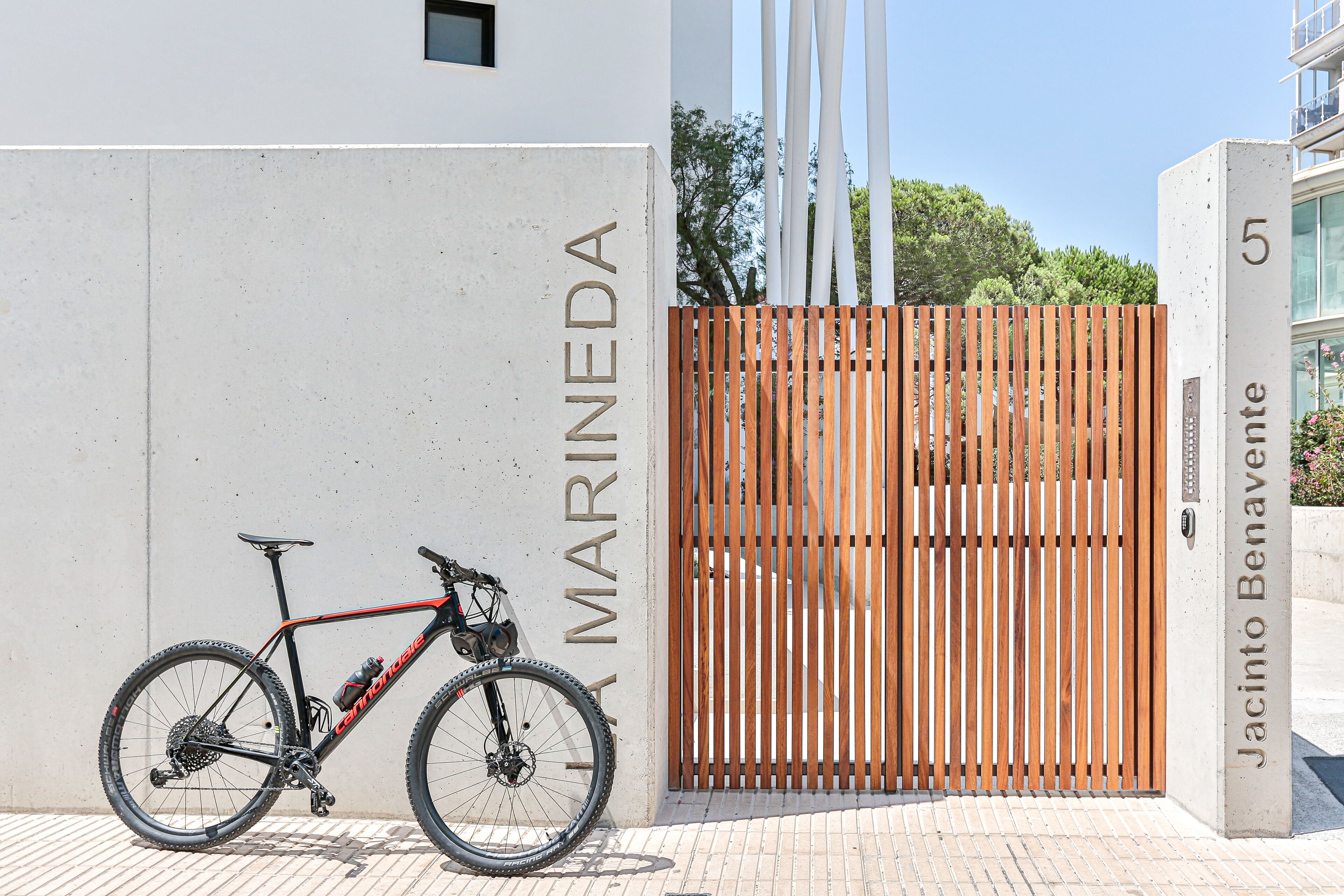 A mountain bike parked against a wall with the text "MARINEDA" and "Jacinto Benavente" visible.