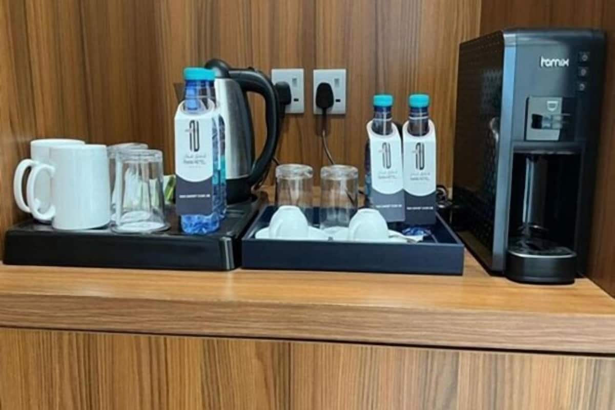Preparación para el desayuno en una habitación de hotel, que incluye una cafetera, botellas de agua, un hervidor y una máquina de café.