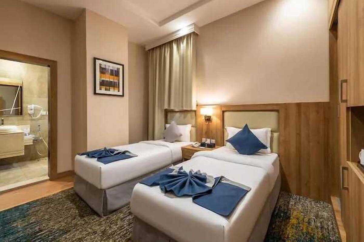 Habitación de hotel con dos camas, un baño y vistas a la ciudad.