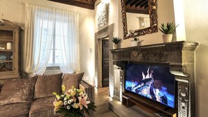 A cozy living room with a fireplace, a television, and a comfortable sofa.