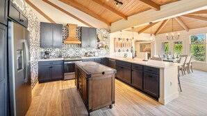 A spacious kitchen with dark cabinets, a central island, and a wooden ceiling. - Brand New 2 Bed/2.5 Bath Renovation, Centrally Located in Sedona (Sedona)
