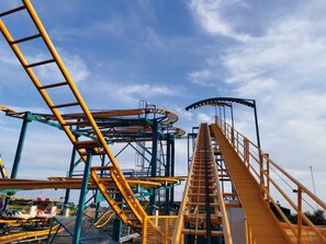 A roller coaster track with a steep drop and a spiral section, surrounded by structural supports and safety barriers. - Gorgeous Horsebox at Glamp in Style in East Sussex (Battle)