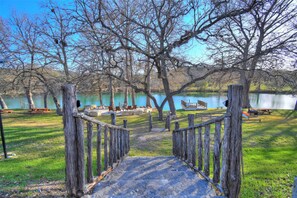 A wooden pathway leading to a lakeside park with picnic tables and benches. - Cabin B at Casa Blanca, 1BR/1BA, Sleeps 4, Porch, Grill (Kerr County)