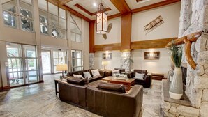 A spacious living room with a large sectional sofa, a coffee table, and a stone fireplace.