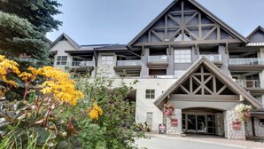 A multi-story building with a prominent entrance, balconies, and a stone facade.