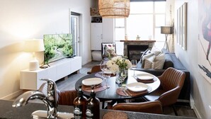 Una sala de estar moderna con comedor, chimenea y televisor.