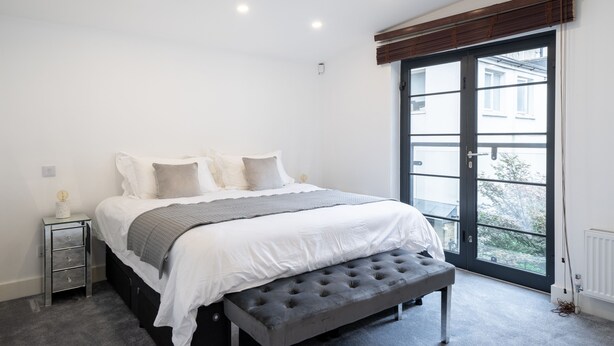 A bedroom with a bed, bedside table, and a window with a view. - SUPERB 3 BEDROOM AND OFFICE COVENT GARDEN HOUSE (London)